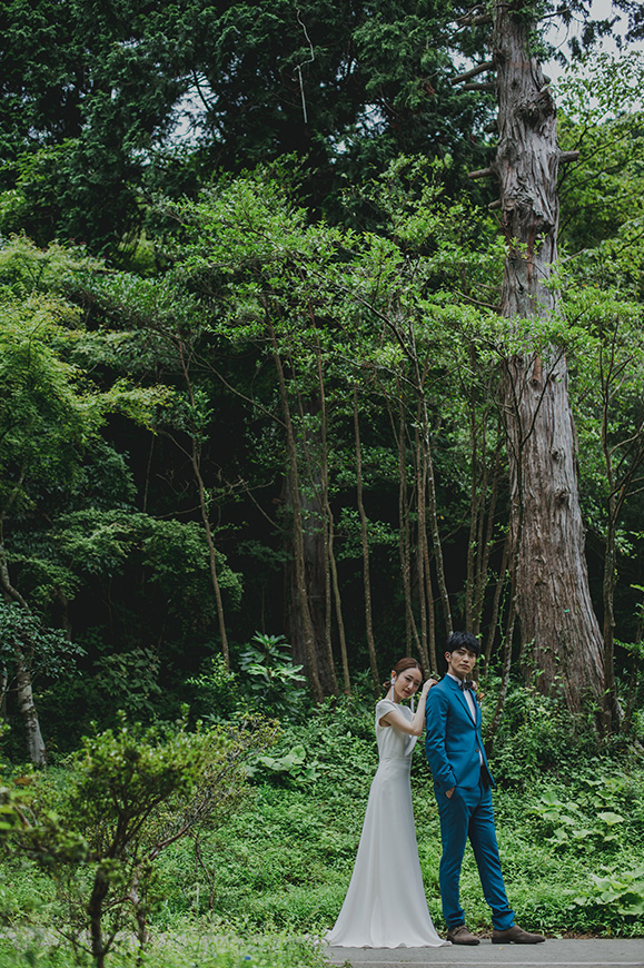 箱根リトリート　オリエント急行室内で佇む新婦のそばで座っている新郎